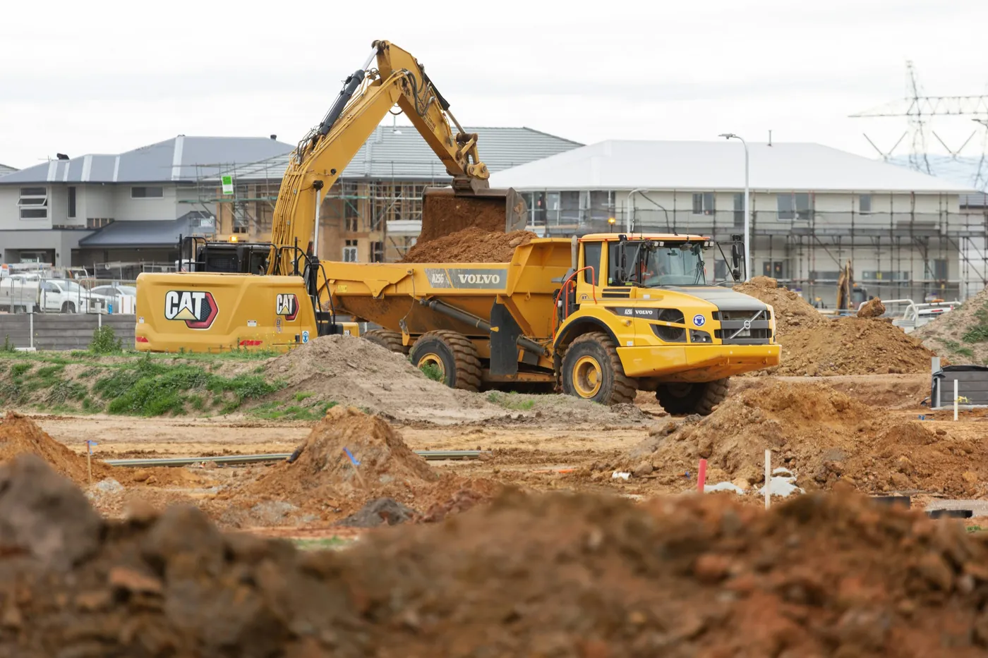 Excavator loading dirt into a dump truck on a construction site, excavation